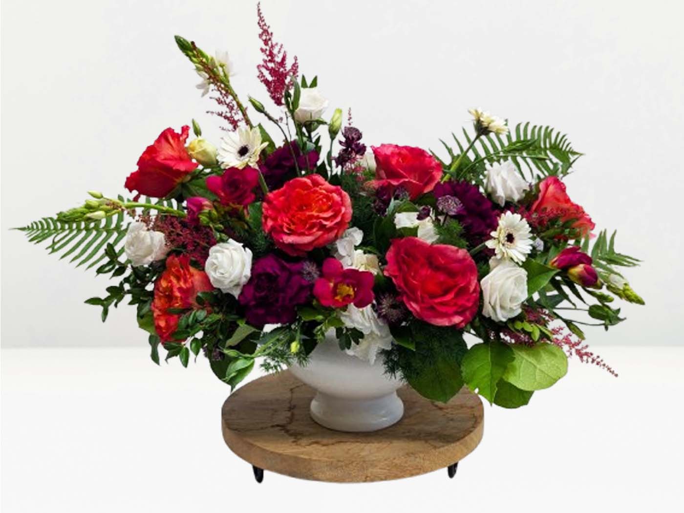 Bouquet of flowers on a wooden stand with a white background